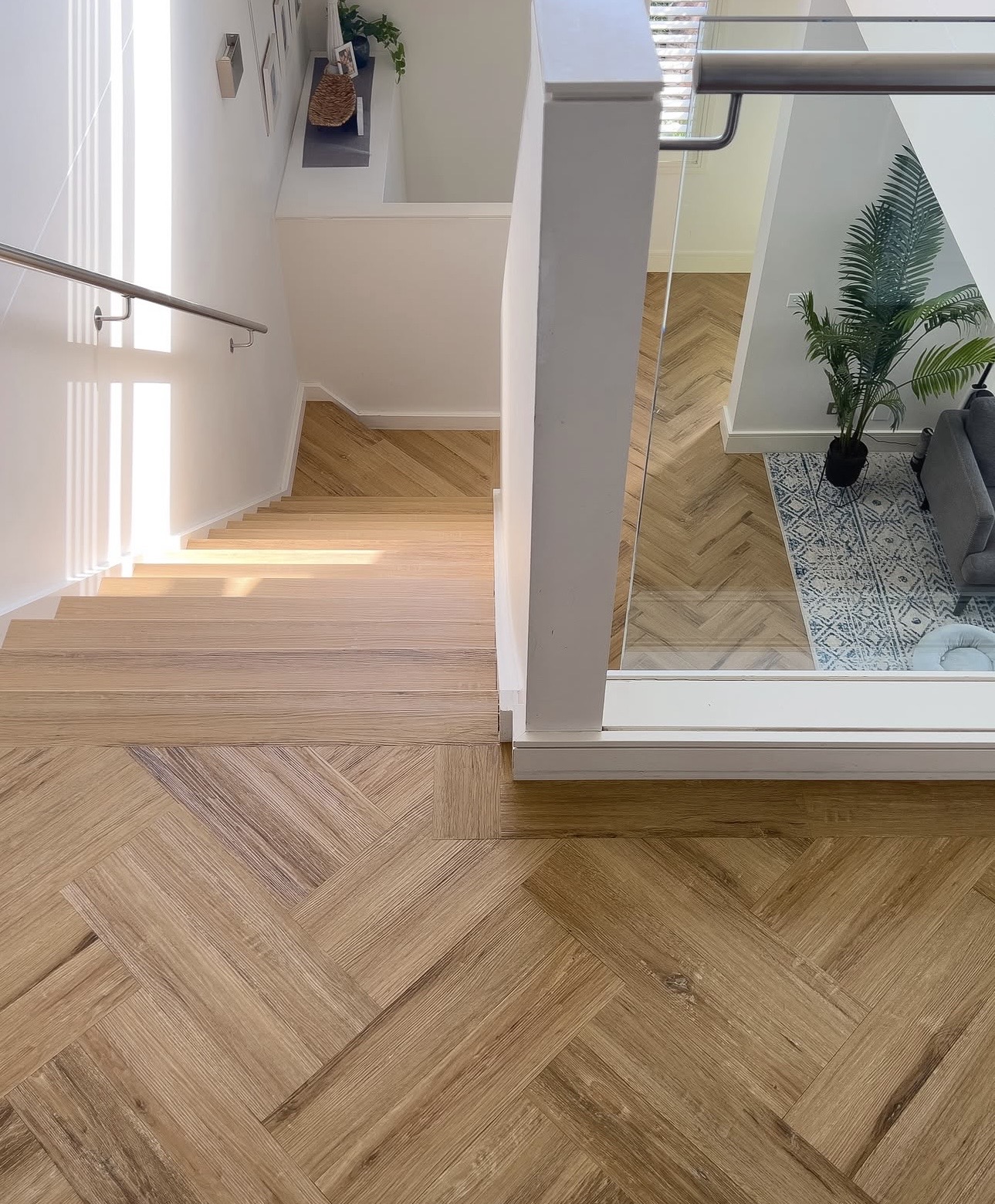 Herringbone hybrid flooring and matching stair treads in a Gold Coast home