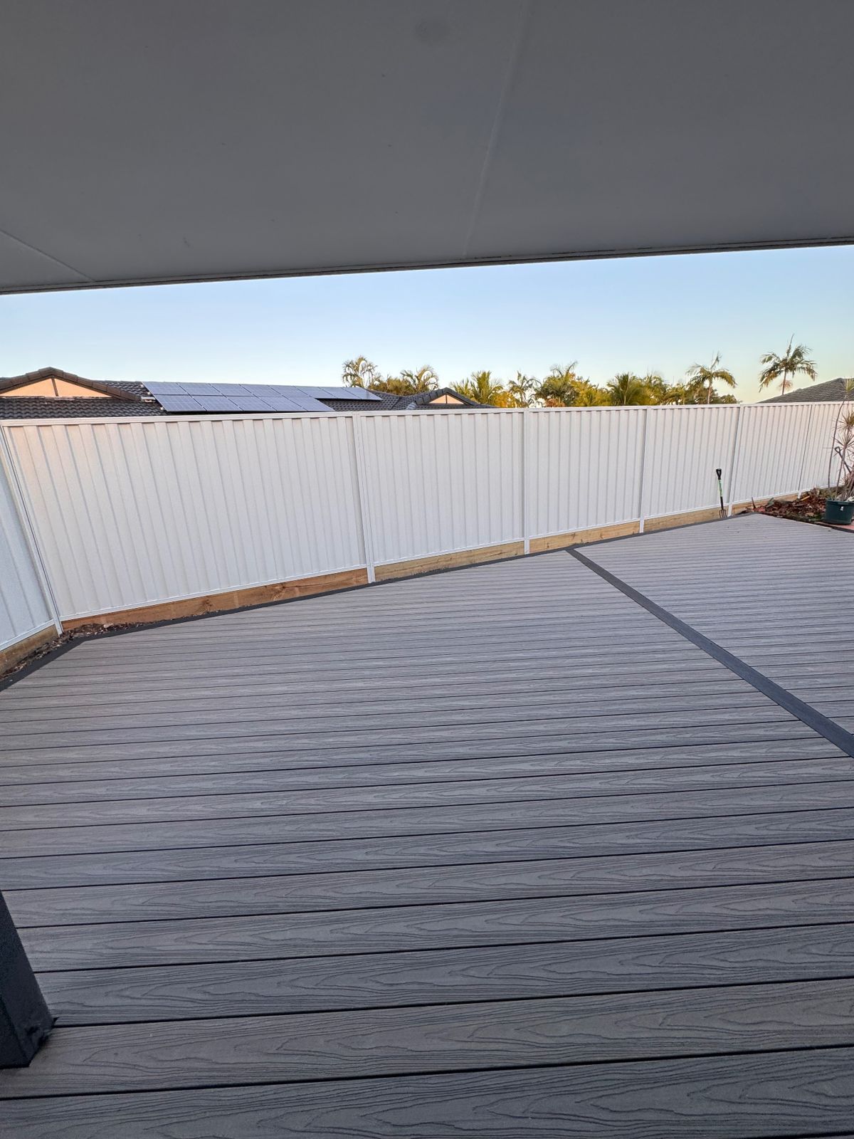 Grey composite decking with contrasting dark border boards under a covered patio on the Gold Coast