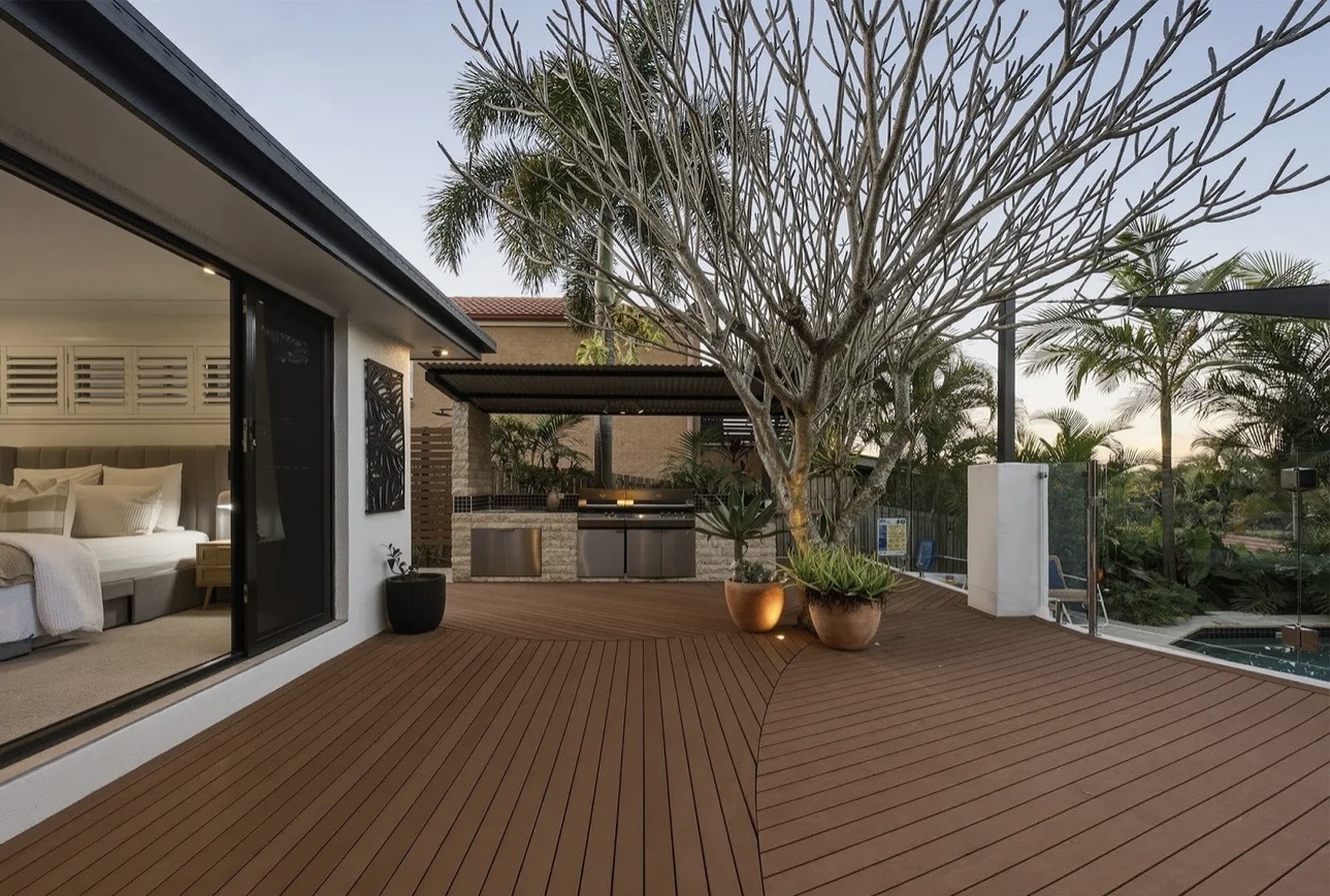 Curved composite deck with outdoor kitchen beside a pool, Gold Coast home