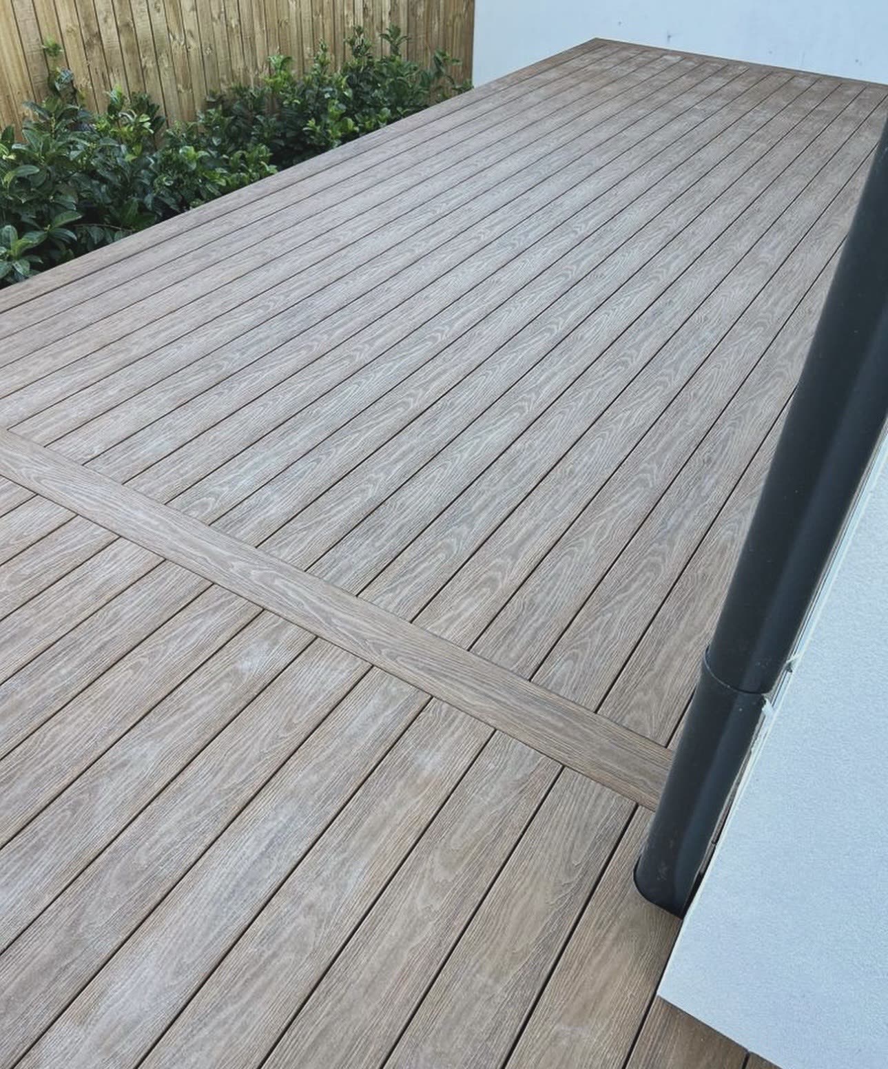 Composite decking with a breaker board detail beside a garden