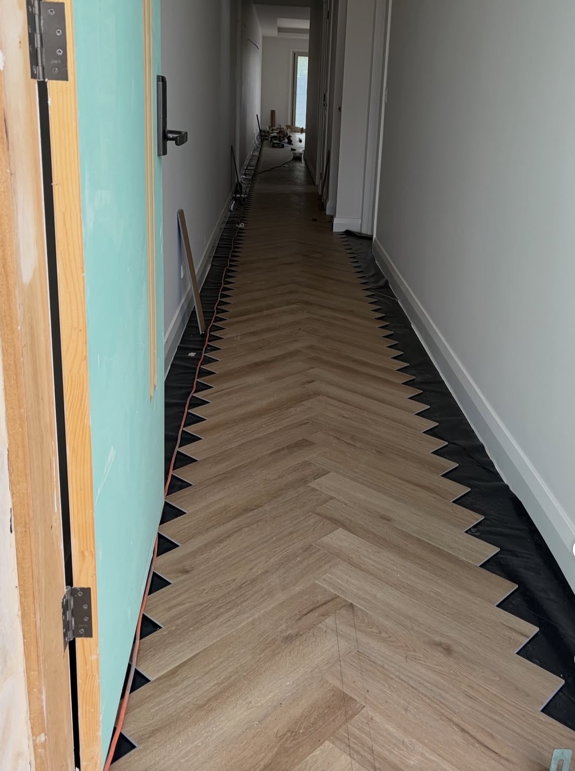 Herringbone hybrid flooring being laid along a Gold Coast hallway