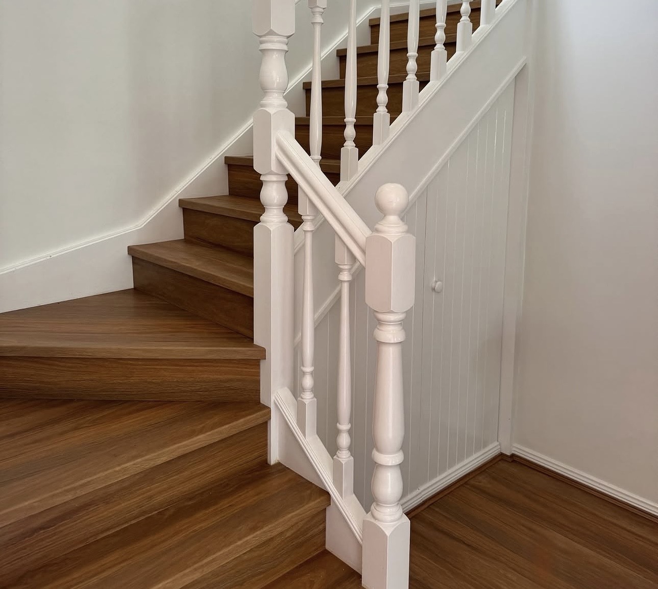 Timber-look hybrid stair treads beside a white balustrade, Gold Coast