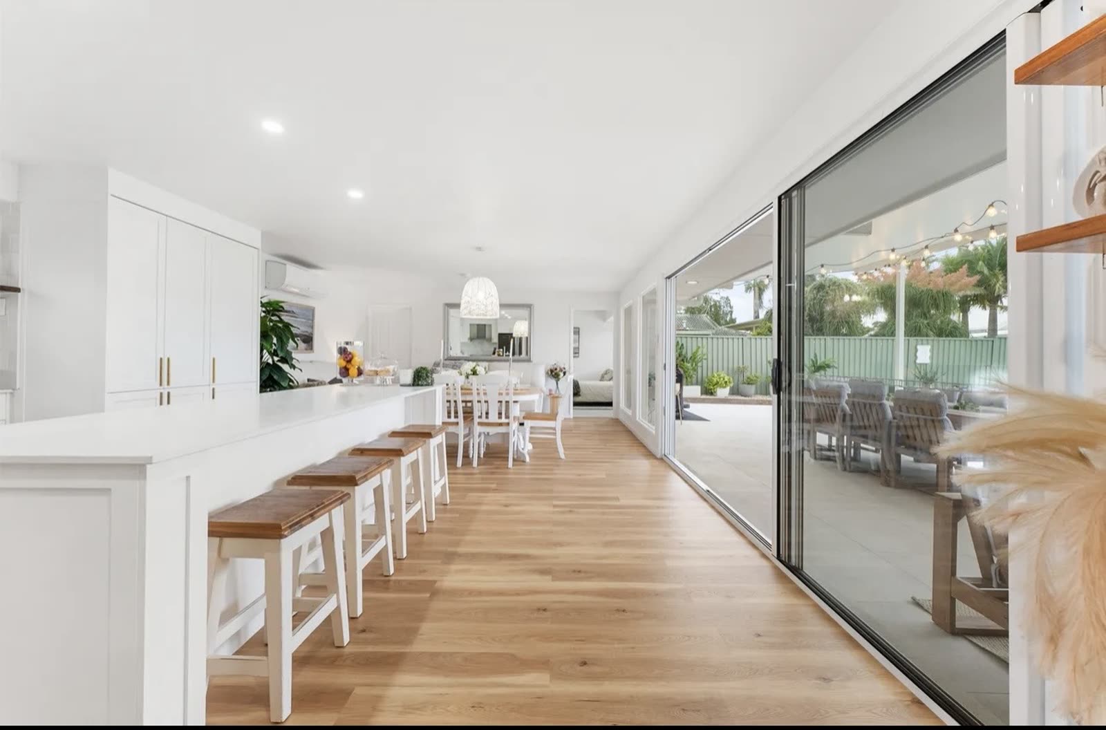 Renovated kitchen and dining space with hybrid timber-look flooring and stacker doors