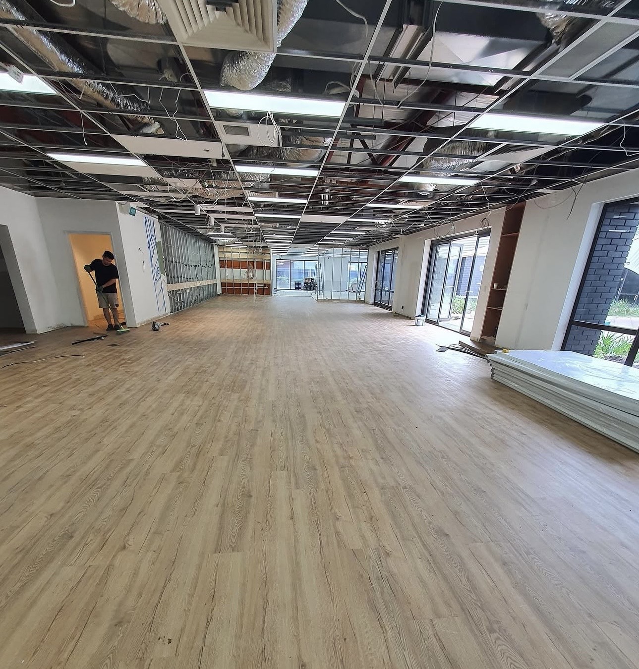 Light oak-look hybrid flooring across a Gold Coast commercial fit-out