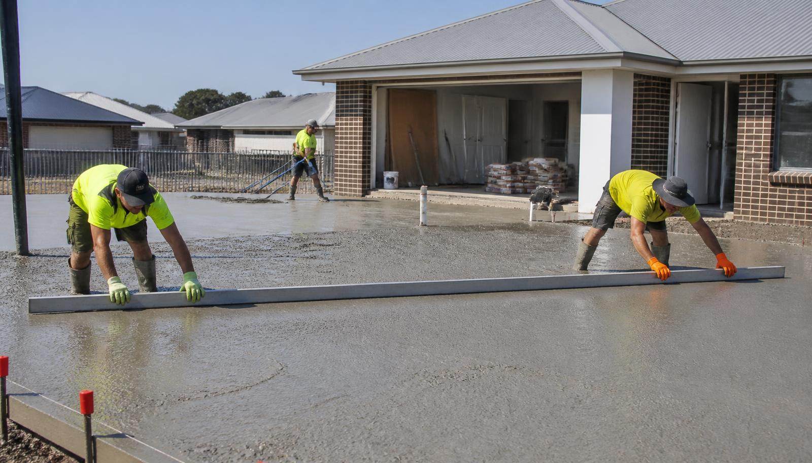 Concrete being placed and screeded on a residential slab