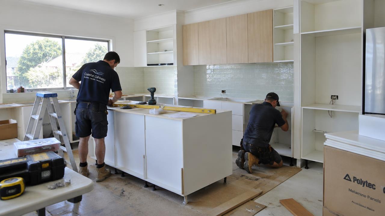 Tradesperson installing custom cabinetry during a Gold Coast kitchen renovation